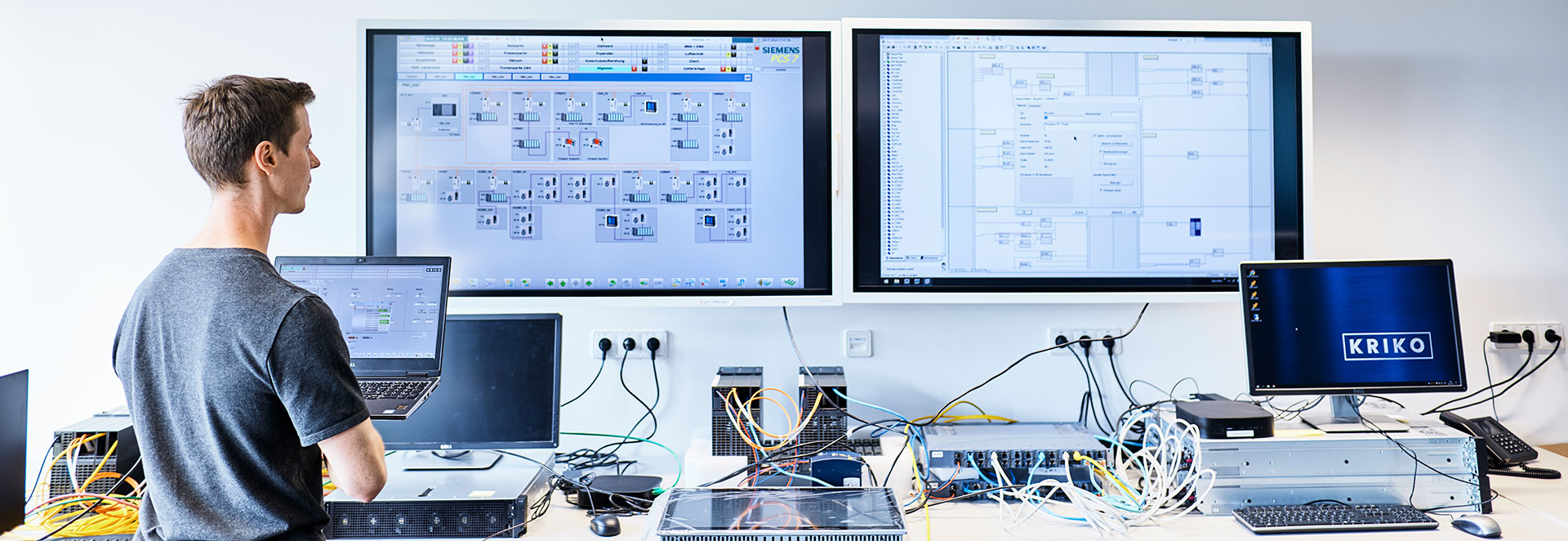 Technician looks at process control system PCS 7 on huge screen